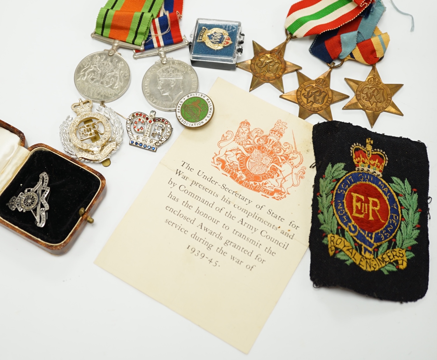 A WWII medal group, comprising of the 1939-1945 War Medal, the Defence Medal, the Africa Star, the Italy Star and the 1939-1945 Star, together with a Royal Artillery sweetheart badge, a cap badge and various other items.